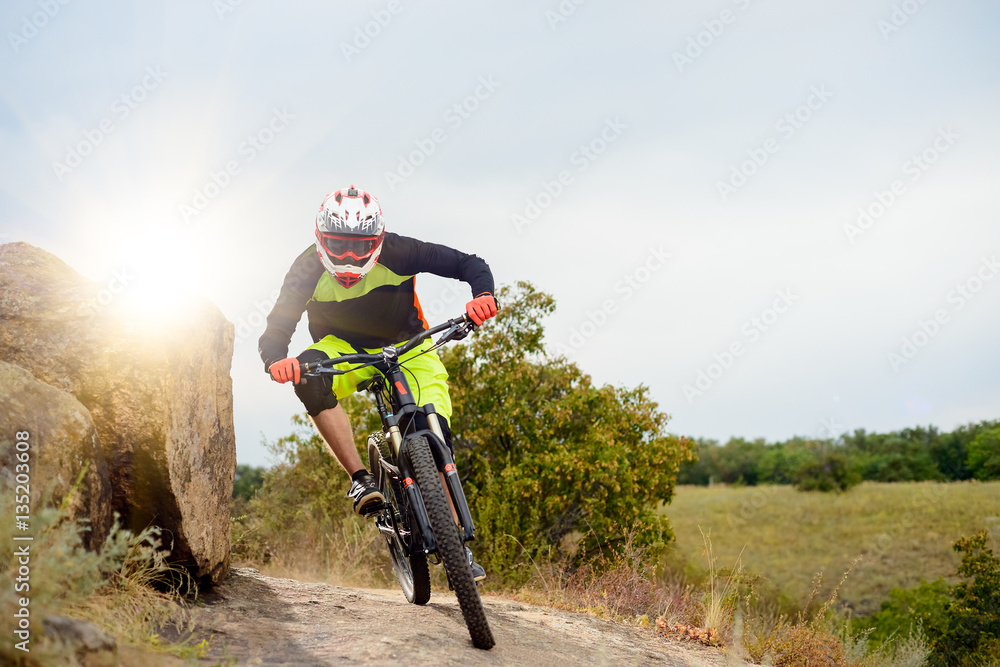 Naklejka premium Professional Cyclist Riding the Bike at the Rocky Trail. Extreme Sport Concept. Space for Text.