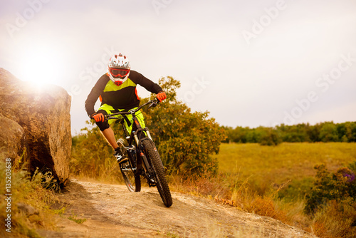 Professional Cyclist Riding the Bike at the Rocky Trail. Extreme Sport Concept. Space for Text.