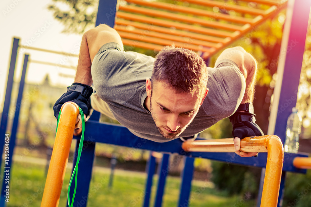 Obraz premium Push-ups - fitness man training push up outside in summer.