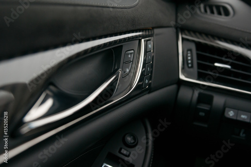 Car interior, dashboard, trims, air vent and door handle. Lock and unlock buttons. © vpilkauskas