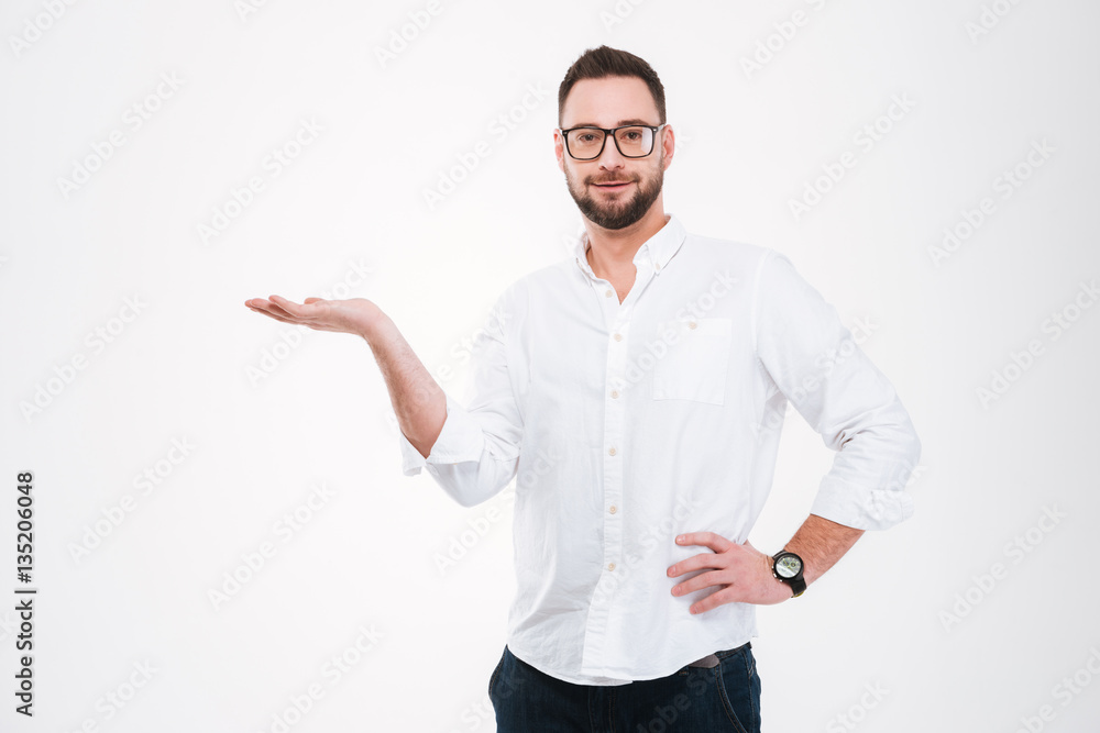 Smiling young bearded man holding copyspace in hand Smiling young bearded man holding copyspace in hand
