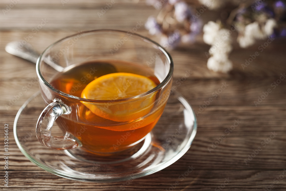 tea with lemon on a wooden table with wildflowers tea with lemon on a wooden table with wildflowers