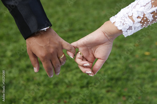 Bride and groom's hands with joined fingers © sidneydealmeida