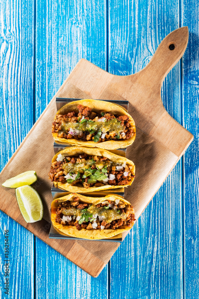 Mexican tacos campechanos top view on a blue wooden table.