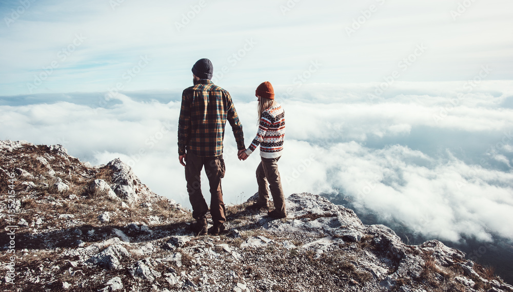 Couple Man and Woman walking in mountains holding hands over clouds Love and Travel happy emotions Lifestyle concept. Young family traveling active adventure vacations Couple Man and Woman walking in mountains holding hands over clouds Love and Travel happy emotions Lifestyle concept. Young family traveling active adventure vacations