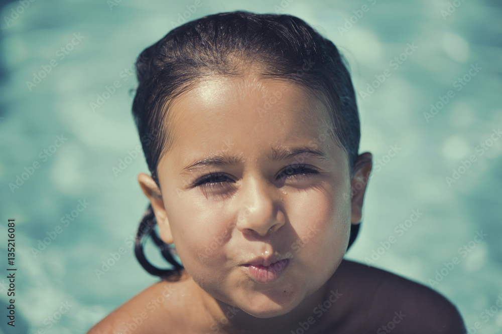 The little Italian girl playing near the pool in the summer The little Italian girl playing near the pool in the summer