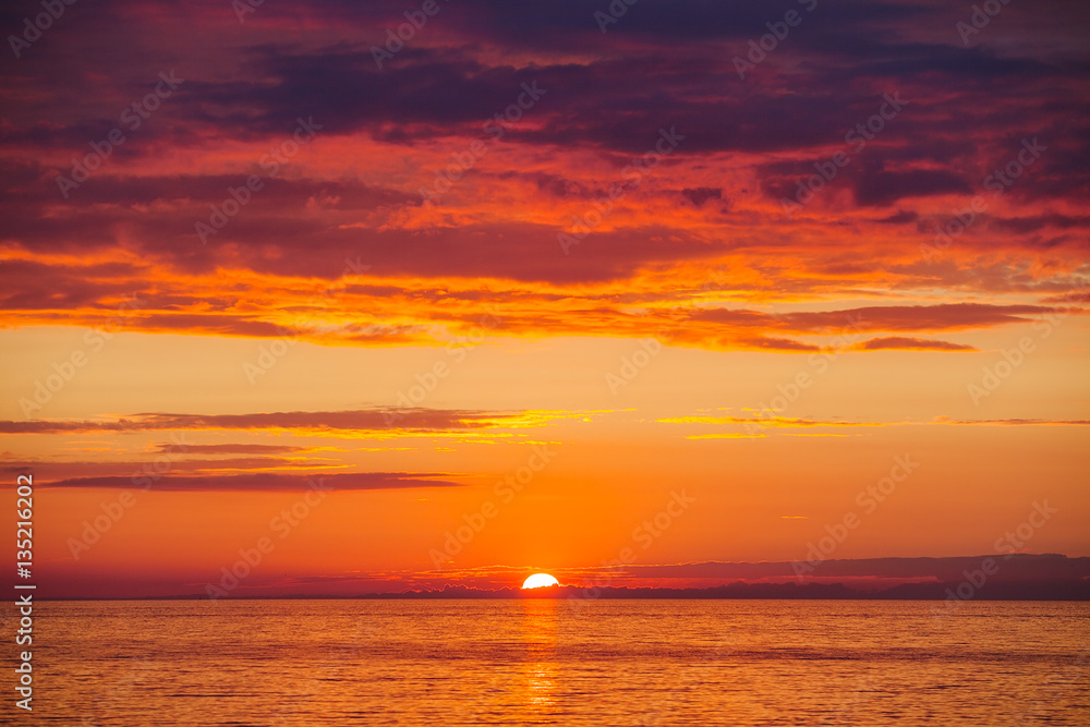 Amazing gold orange sky and water of Baltic sea at sunset