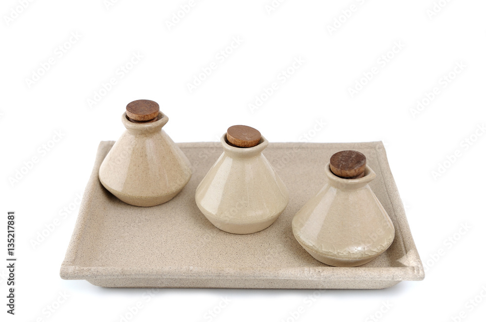 Classic clay bottles lay on tray, isolated. Classic clay bottles lay on tray, isolated.
