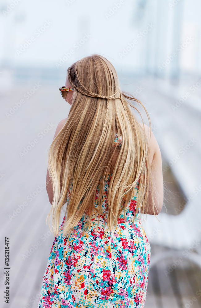 Back view of the young female with beautiful blond straight long hair ...