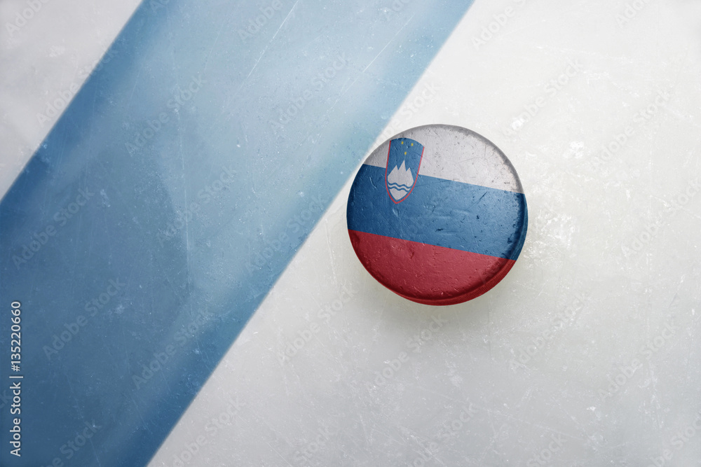 Naklejka premium old hockey puck with the national flag of slovenia.
