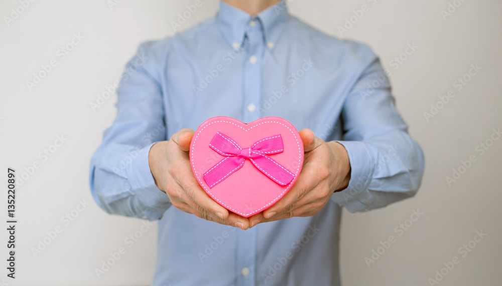 man holding a gift box in the form of heart man holding a gift box in the form of heart
