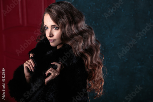 Young brunette woman with perfect natural makeup and hair style wearing furs. fashion beauty portrait 