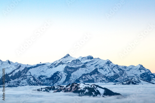 Swiss mountain range with clouds during sunrise near Gstaad, Bernese Oberland, Switzerland