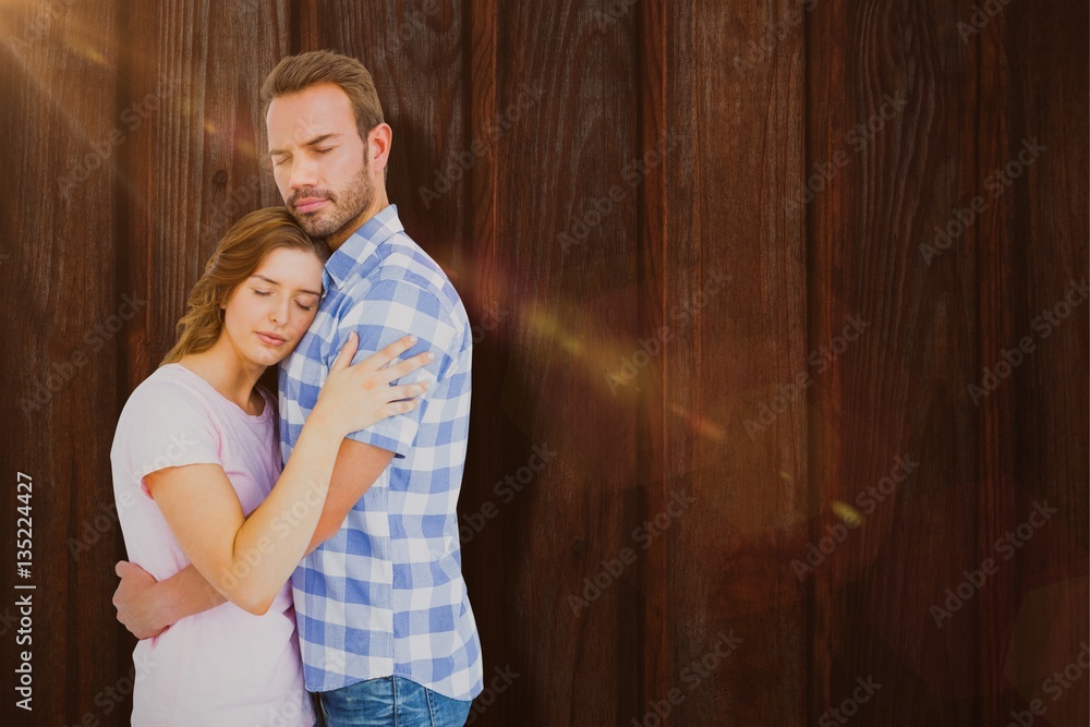 Composite image of happy young couple cuddling each other