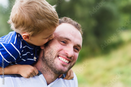 Child playing with his father. Daddy playing active games with his son outside. Happy family portrait. Laughing dad with little boy enjoying nature together. © o_lypa