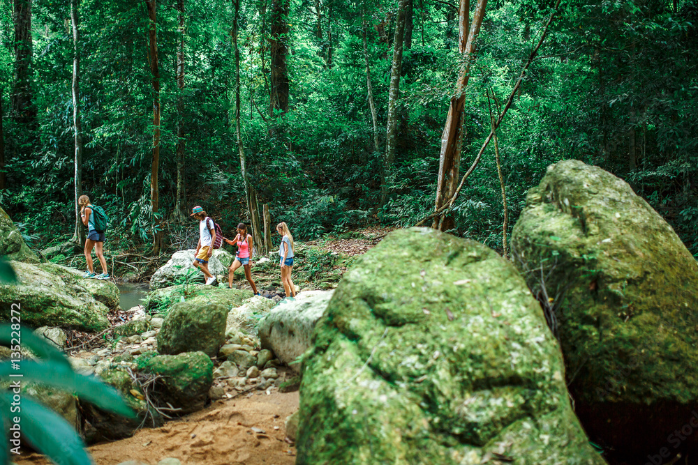 Naklejka premium group of hikers exploring jungle in thailand