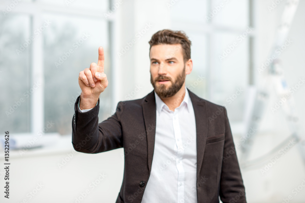 Businessman or architect touching virtual screen standing in the room Businessman or architect touching virtual screen standing in the room