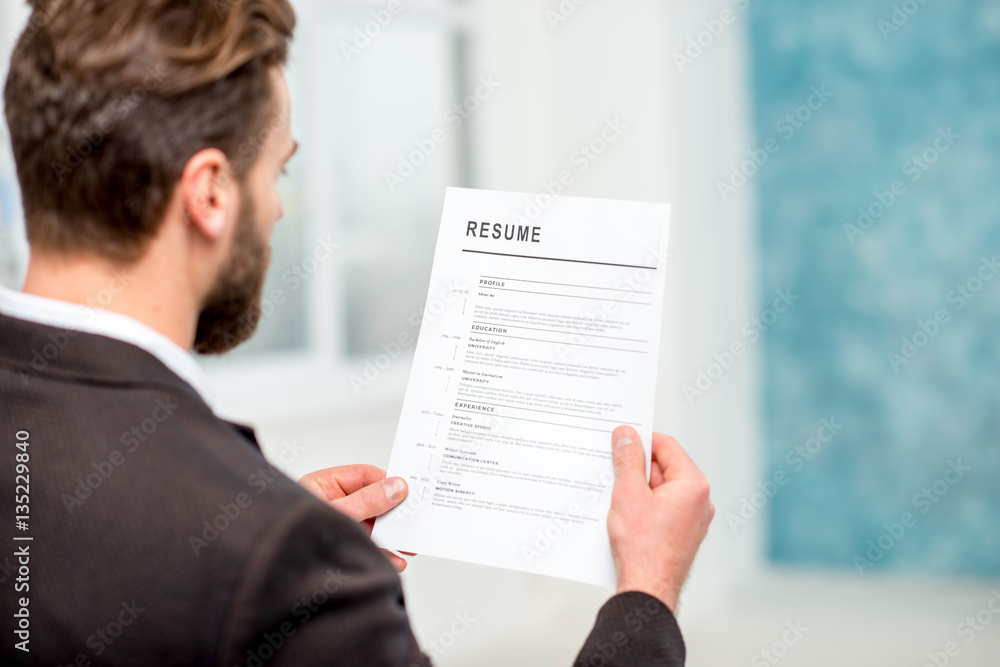 Elegant recruiter reading resume for job hiring in the office Elegant recruiter reading resume for job hiring in the office