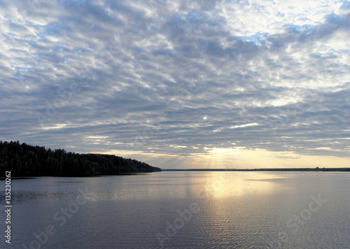 View of the golden sunset on the river with clouds and the Sun reflected in it  Volga  Russia