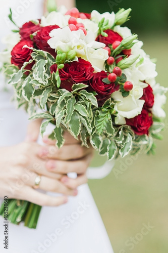 Fototapeta Naklejka Na Ścianę i Meble -  Bride holding wedding flowers bouquet