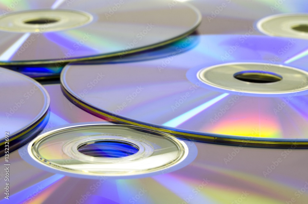 Many CD or DVD disc media laying on table Many CD or DVD disc media laying on table