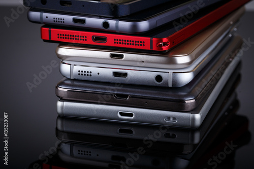 Heap of electronical devices close up - smartphones on black bac