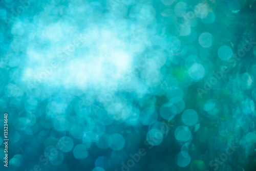 blurred closeup of turquoise glittering christmas decoration ornaments, abstract background