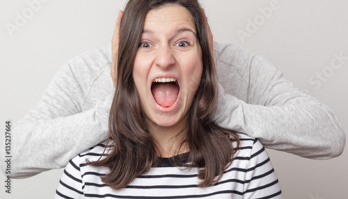 Принти на полотні Girl screaming hysterically. Guy plugs her ears