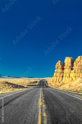 on the road in the desert of rocks and mountains in the United States in Utah with blue sky and clouds