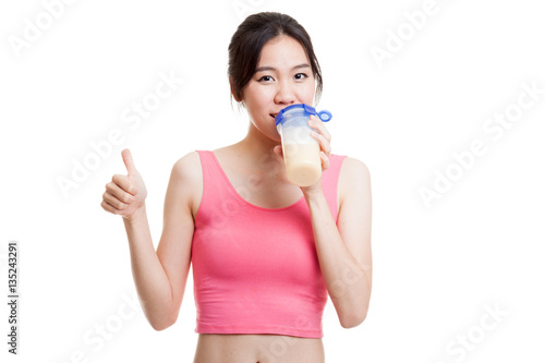 Beautiful Asian healthy girl show thumbs up  drink whey protein.