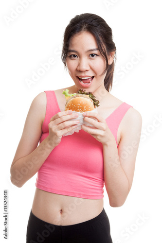 Beautiful Asian healthy girl enjoy eating  hamburger.