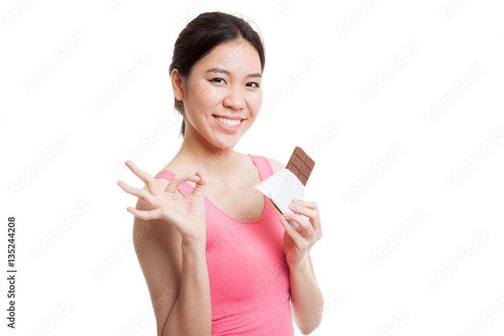 Beautiful healthy Asian girl show OK with chocolate. Beautiful healthy Asian girl show OK with chocolate.