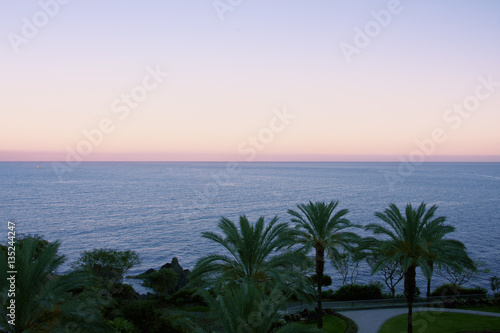 View of the ocean at twilight after sunset with the steep coast of the island Madeira, Portugal.