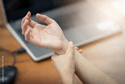 Bild auf Leinwand Woman holding her wrist pain from using computer. Office syndrome