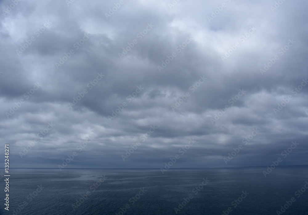 Gushing sea on a cloudy day. Horizontal view of dramatic overcast sky and sea. Fifty shades of blue. Gushing sea on a cloudy day. Horizontal view of dramatic overcast sky and sea. Fifty shades of blue.