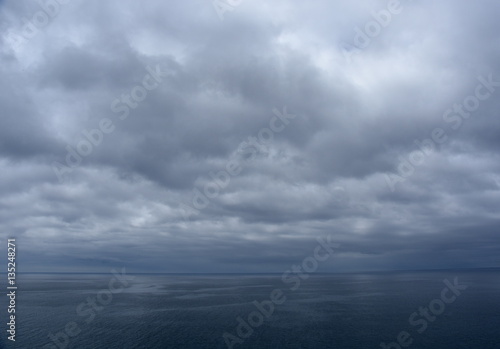 Gushing sea on a cloudy day. Horizontal view of dramatic overcast sky and  sea. Fifty shades of blue. © katacarix