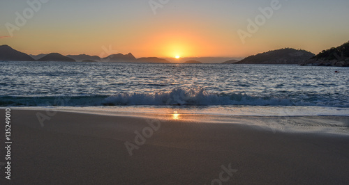 Beautiful Sunrise with the sun rising out of the ocean at the Red Beach  Praia Vermelha  with the Sugarloaf Mountain  Rio de Janeiro