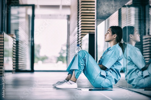 Side view of nurse sitting on floor