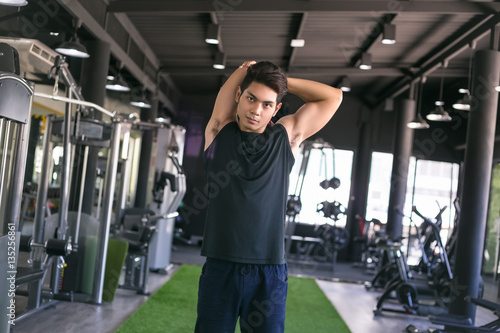 Portrait of a man doing stretching exercises at gym.