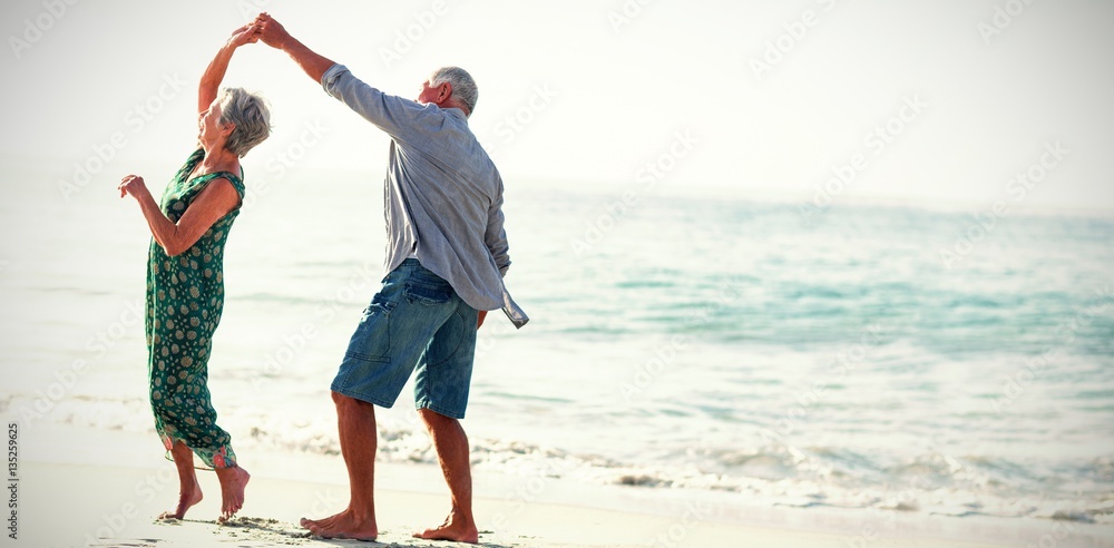 Obraz premium Starszy para tańczy na plaży