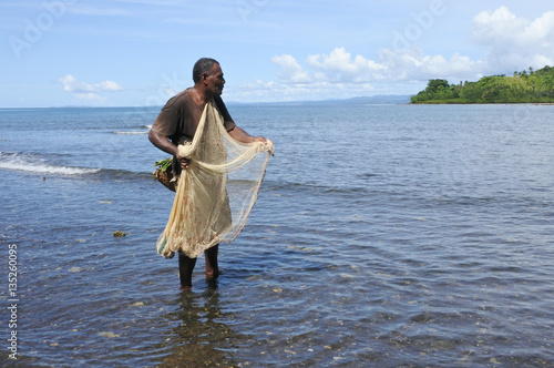 Indigenous Fijian fisherman fishing with a Fishing net in Fiji