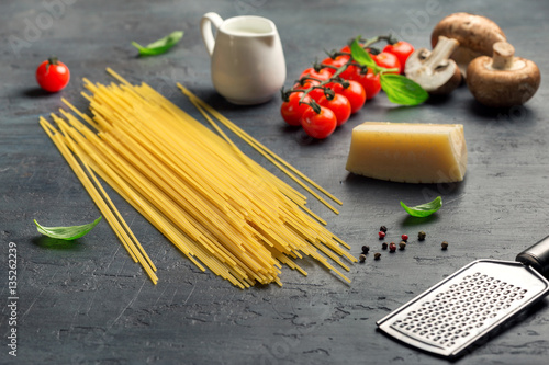 Raw Italian spaghetti with set of ingredients for cooking pasta
