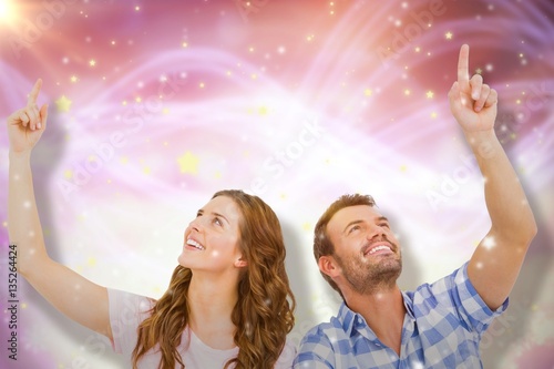 Composite image of young couple looking up and smiling