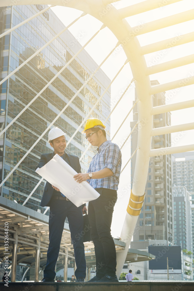 Young Male Architects Discussing with Businessman at Constructio Young Male Architects Discussing with Businessman at Constructio