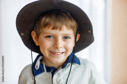 Portrait of little school kid boy wearing cowboy hat photo