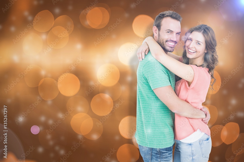 Composite image of happy young couple cuddling Composite image of happy young couple cuddling
