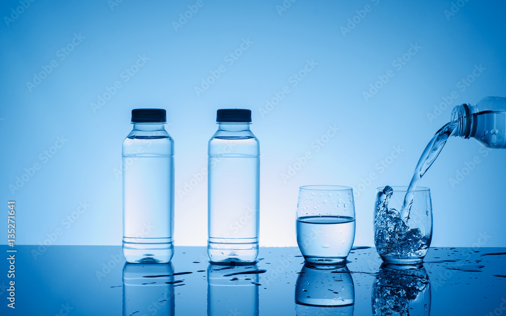 Bottle with creative splashing water in the glass Bottle with creative splashing water in the glass
