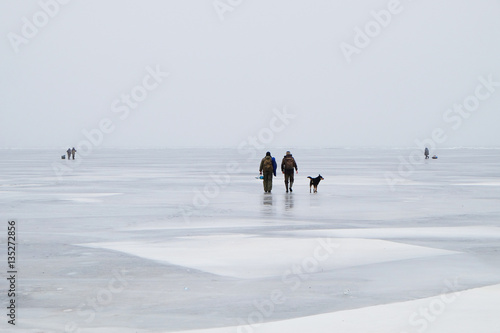fishermen and dog go on winter fishing