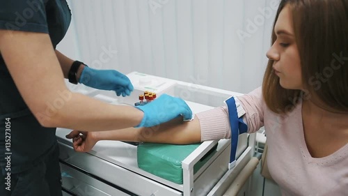 The doctor takes blood from a vein from the woman
