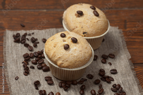 Tasty muffin cakes on burlap, spices and coffee beans